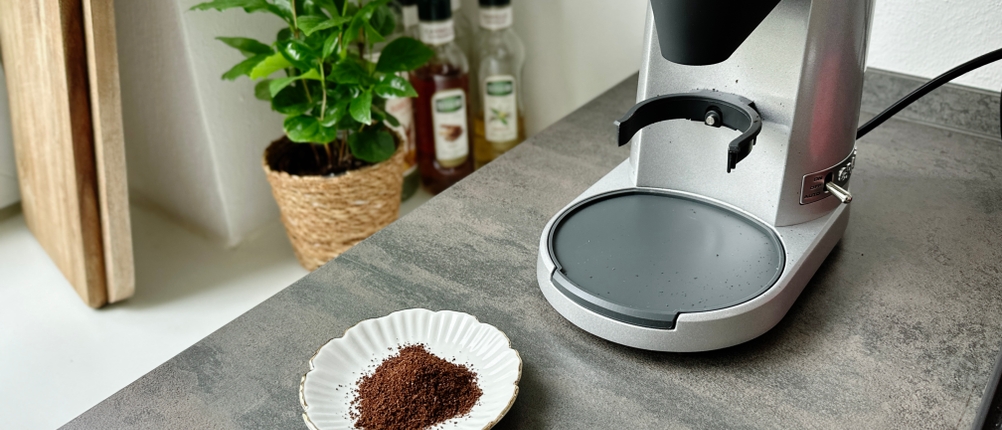 Espressomühlen im Test: Kaffeepulver steht neben einer Espressomühle.
