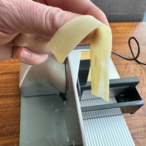 Dünne Käsescheibe mit dem Graef Master M20 geschnitten