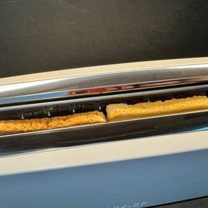 Ein Vollkorntoast und ein Weizentoast stehen während dem Toasten im Graef TO91.