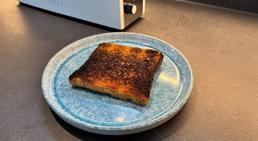 Ein teilweise schwarzes Toast liegt auf einem Teller.