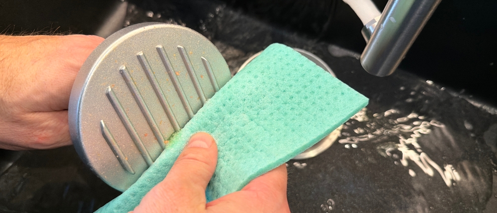 Der Pressstempel aus dem Gräwe-Hamburgerpressen-Set wird mit einem Lappen gereinigt