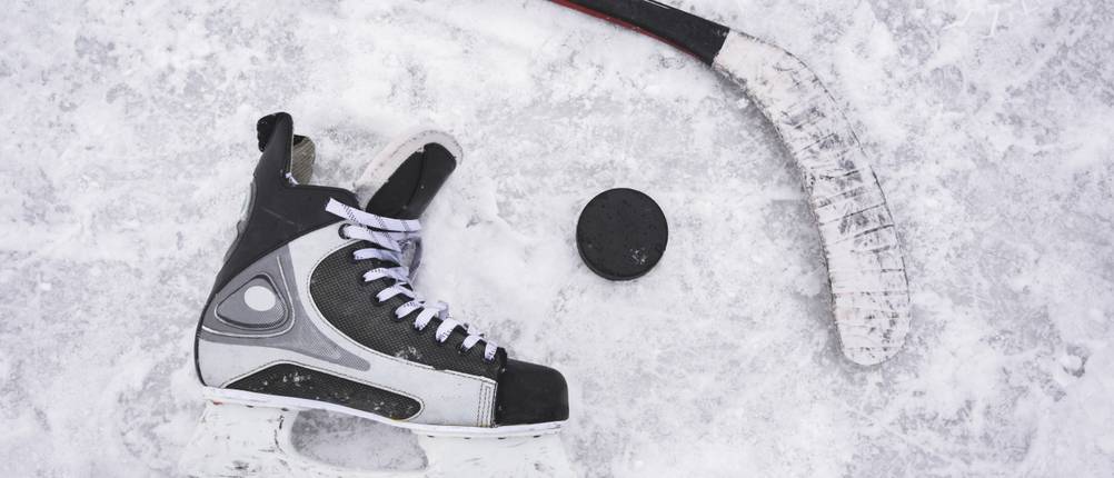 Graf-Schlittschuhe im Test: ein einzelner Schlittschuh liegt mit Eishockey-Stock und Puck auf dem Eis.
