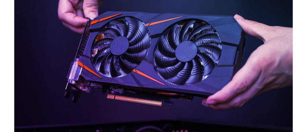 Mining-Rigs im Test: Ein Mann hält eine Grafikkarte in der Hand