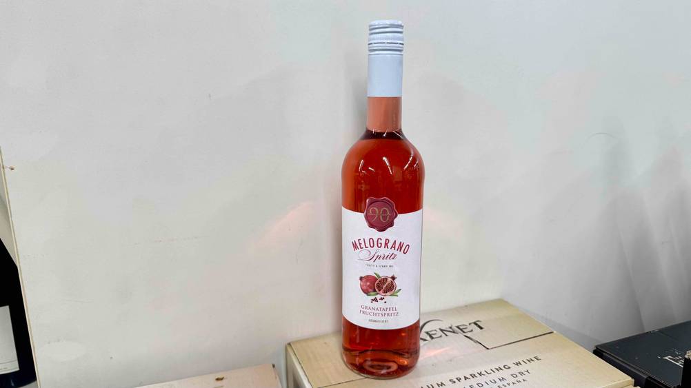 Granatapfelwein im Test: Eine Flasche auf einem Karton vor einer hellen Wand.