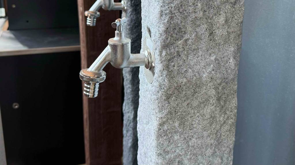 Detailansicht des Wasserhahnanschlusses an einer getesteten Wasserzapfsäule.