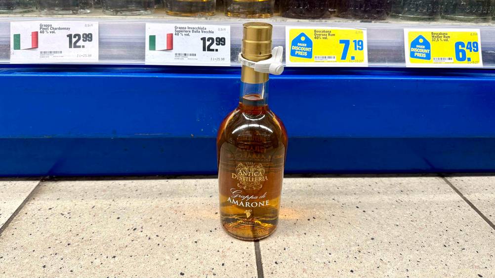 Vor einem Verkaufsregal auf dem Boden steht der Grappa Amarone im Test.