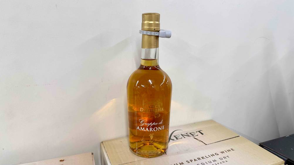 Eine Flasche des getesteten Grappa Amarone auf einem Karton vor einer hellen Wand.
