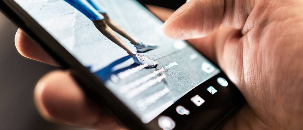 Eine Person ist am Handy und nutzt Social Media.