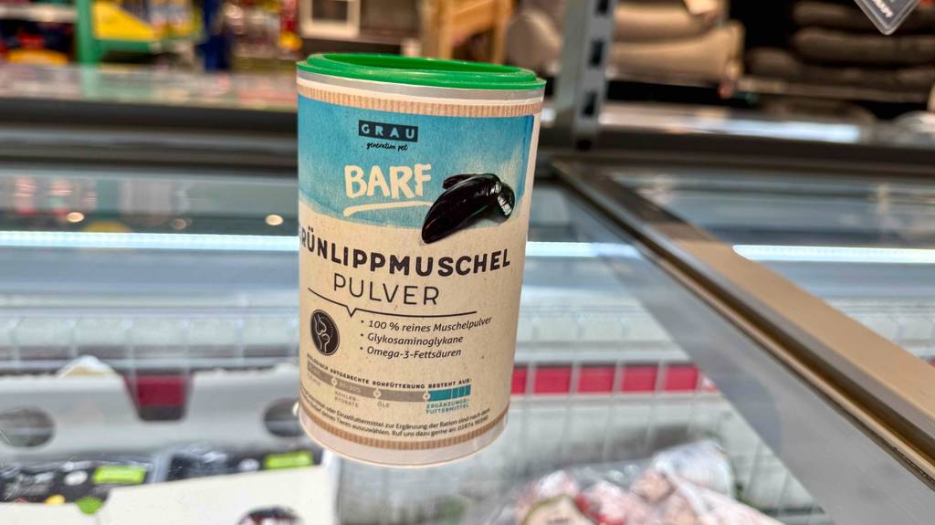Eine Dose getestete Grünlippmuschel für den Hund steht auf einer Glasfläche.