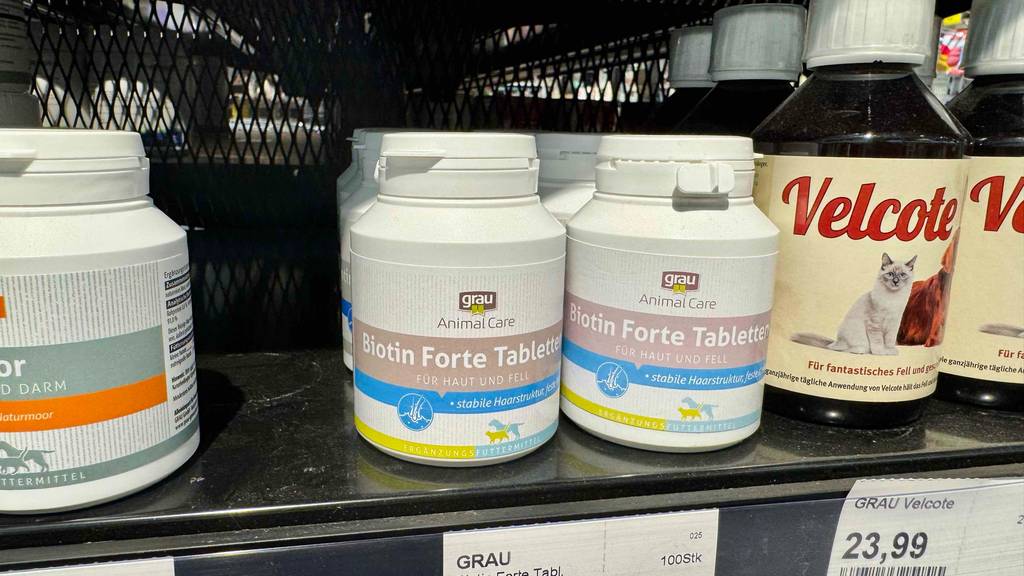 Biotin für Hunde im Test: Mehrere Dosen stehen zwischen anderen Produkten in einem Regal.