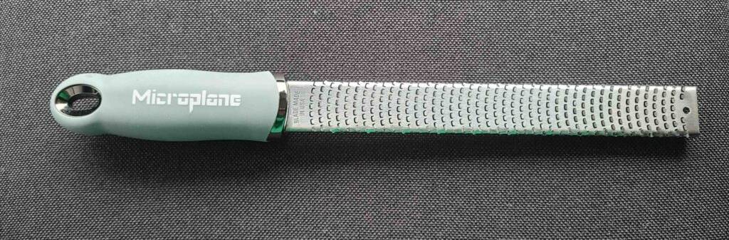 Die Microplane-Reibe im Test liegt auf einem grauen Stoff.