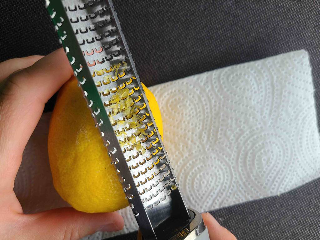 Eine Hand reibt mit der getesteten Microplane-Reibe auf einer Zitronenschale.