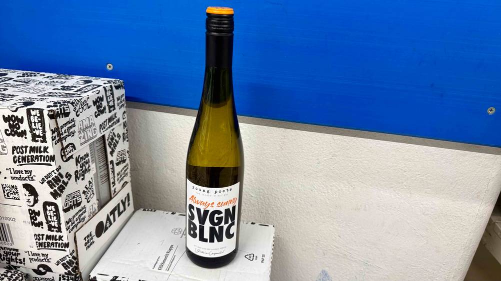 Getestet: Eine Flasche des Grauburgunder Pfalz steht auf einem Karton vor einer blauen Fläche.