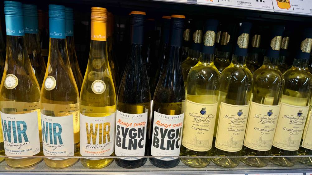 Mehrere Flaschen des getesteten Grauburgunder Pfalz in einem Verkaufsregal neben anderen Flaschen.