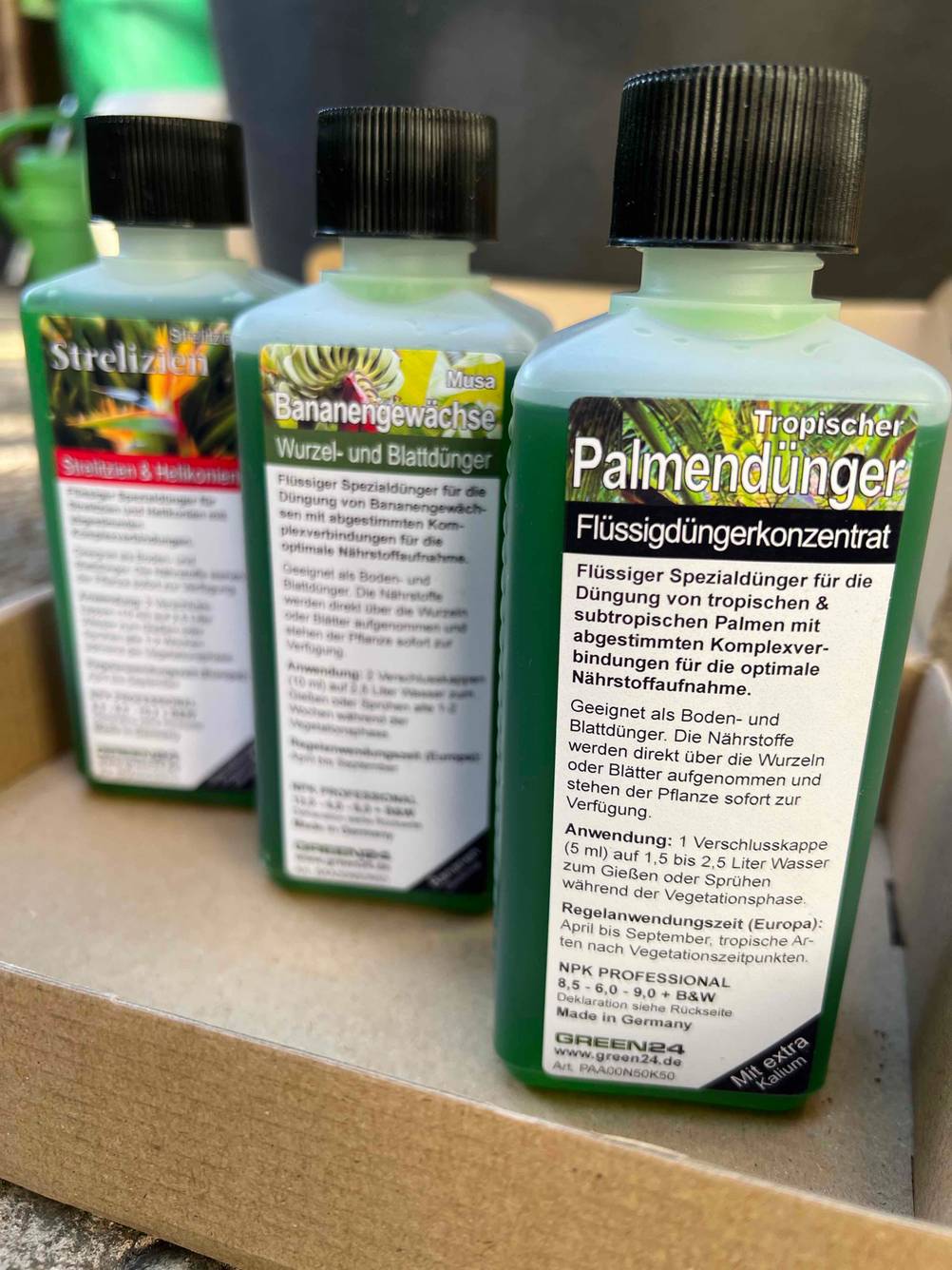 Mehrere Flaschen von Dünger für Palmen, Strelizien und Bananengewächse der Marke green24 mit Informationen zur Anwendung und Verwendung.