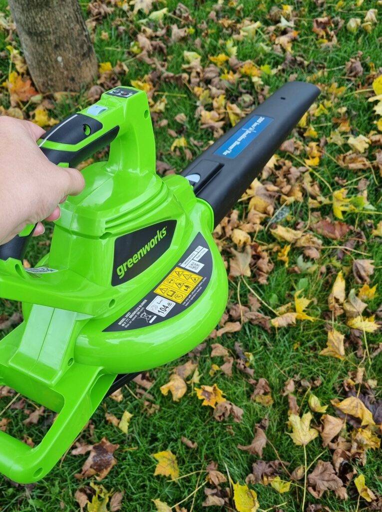 Laubsauger wird beim Test in der Hand gehalten und Laub gesaugt.