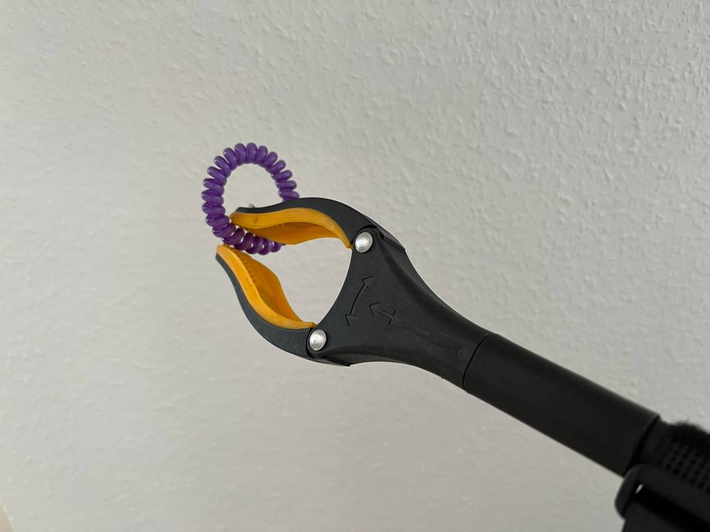 Greifzange mit einem Haargummi.