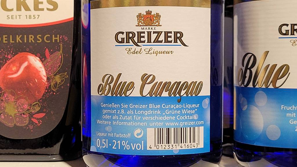 Im Test: Der Blue-Curacao-Sirup in der Flasche steht in einem Regal.