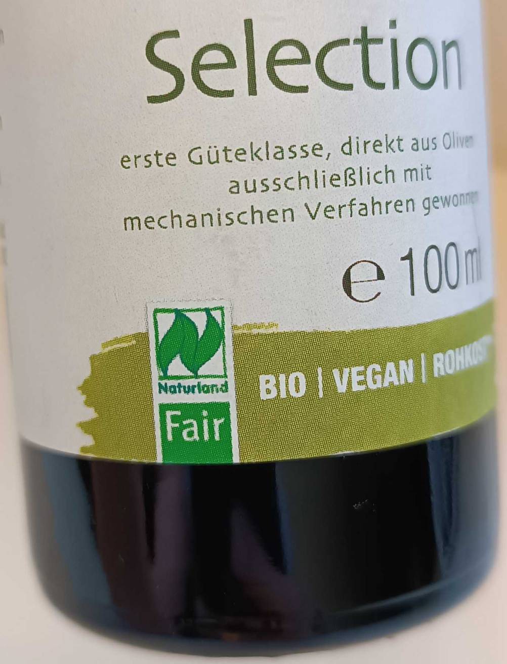 Nahaufnahme des Labels auf der Vorderseite einer Flasche griechischen Olivenöls mit Naturland Aufdruck.