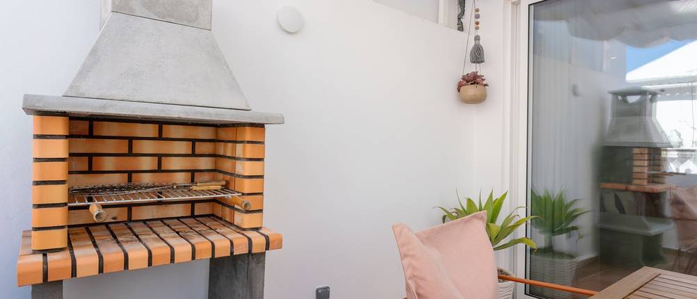 In Die Wand eingelassener Kamingrill nahe einer Terrasse.