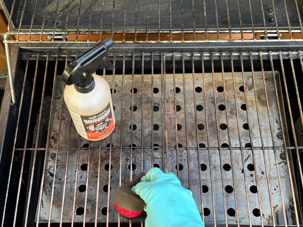 Eine Person reinigt im Test mit dem Bio-chem-Grillreiniger einen Grillrost.