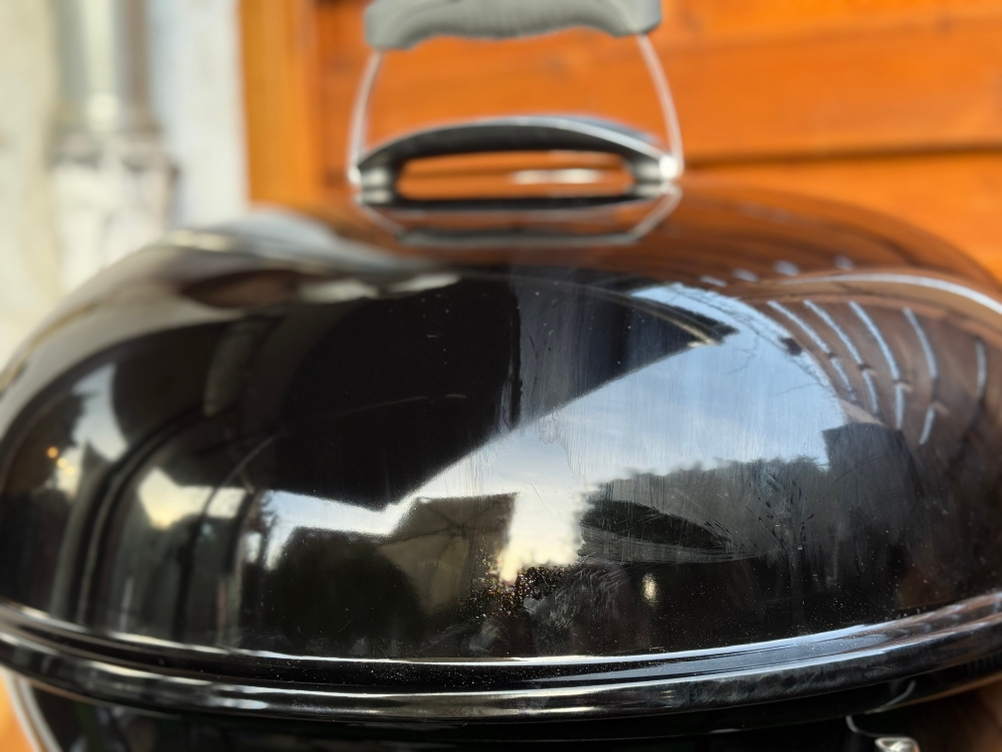 Polierter Deckel eines Kugelgrills, welcher teilweise mit dem Pflegeöl des getesteten Grillreinigers von Bio-chem behandelt wurde.