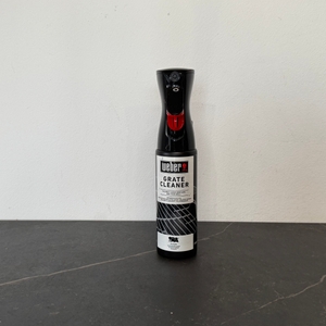 Der getestete Grillreiniger von Weber auf einem Tisch vor einer weißen Wand.