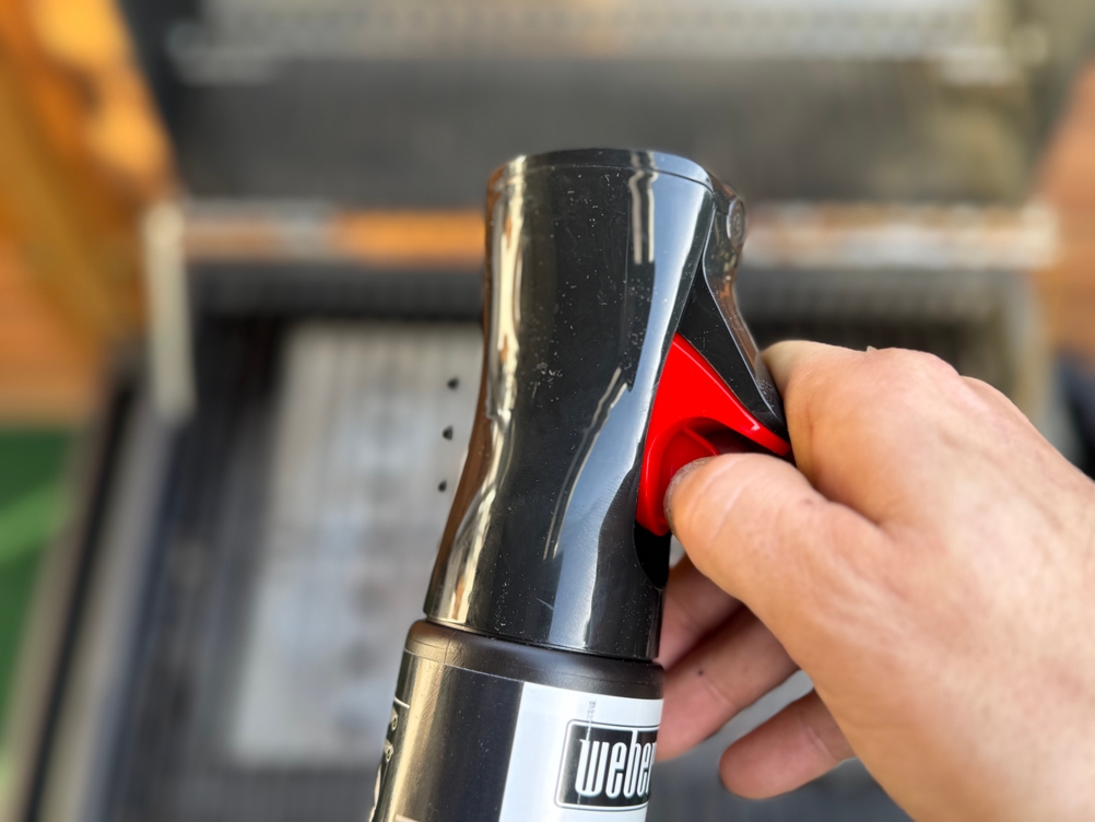 Eine Person entfernt die Sicherheitskappe vor dem Test des Weber-Grillreinigers.