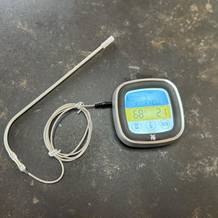 Das getestete Grillthermometer von WMF mit dem Messfühler auf einem Tisch.
