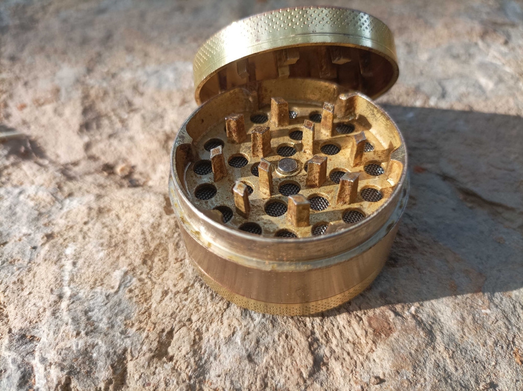 Grinder im Test: Der Deckel eines Grinders lehnt an den Grinder, mit Blick auf die Messer.