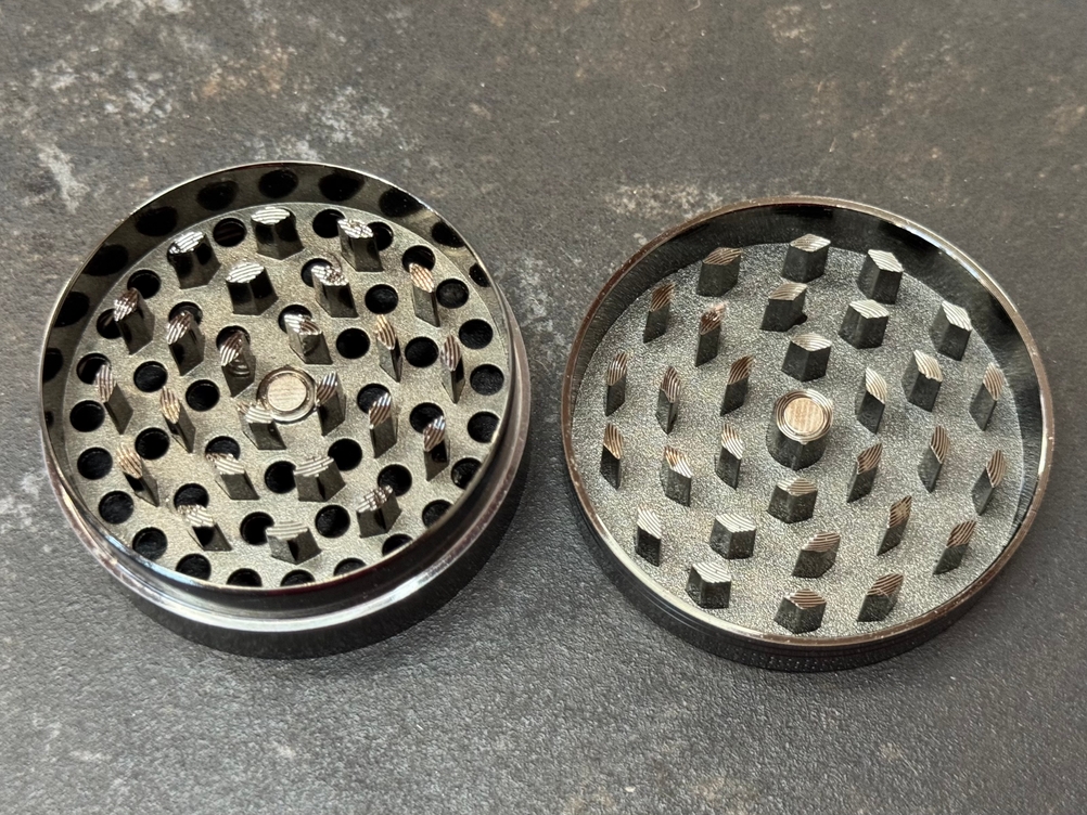 Deckel und Schneidkammer des getesteten Kitchenboss-Grinders liegen nebeneinander auf einer Arbeitsfläche.