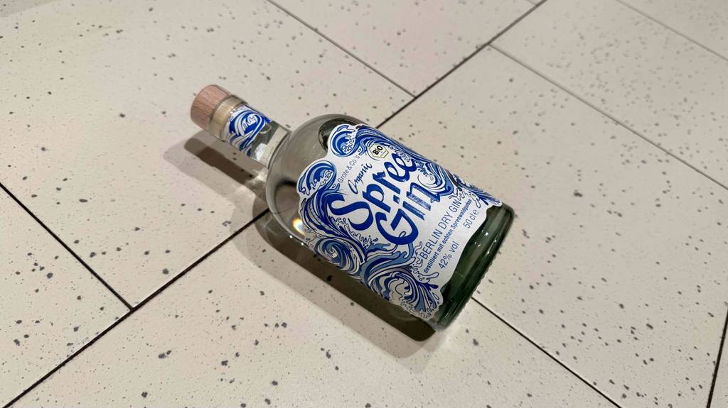Eine Flasche getesteter Deutscher Gin liegt auf einem hellen Fliesenboden.