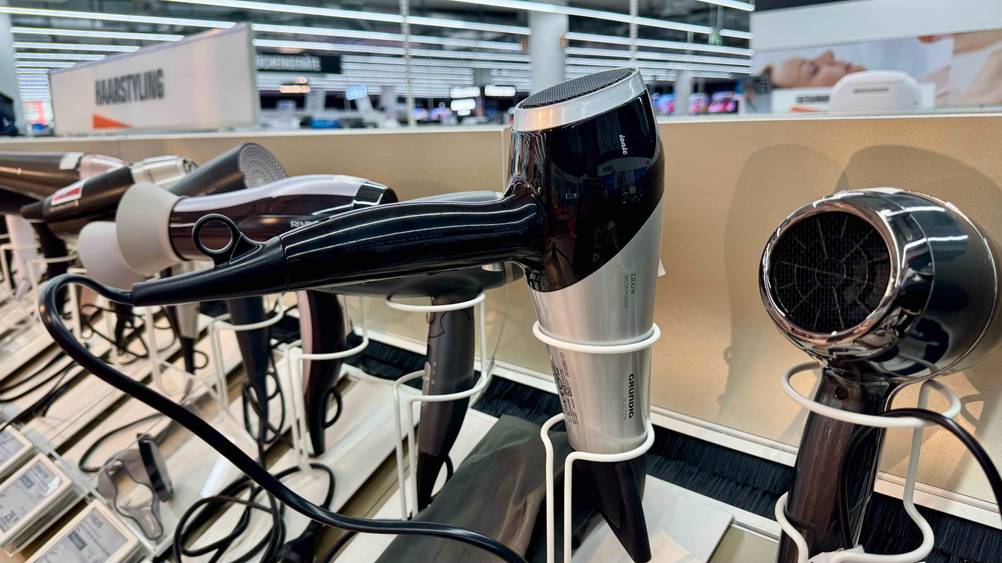 Der Grundig-Haartrockner im Test in einem Ständer neben anderen Produkten.