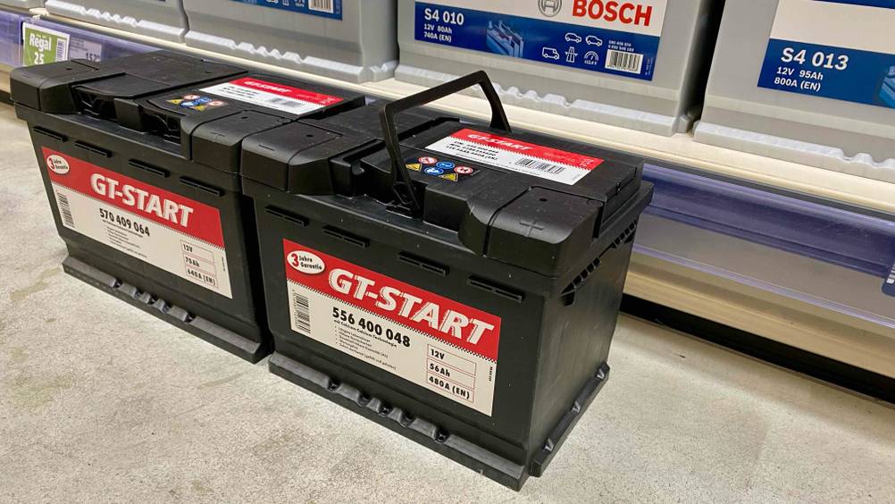 Autobatterie getestet: Zwei Batterien nebeneinander vor einem Verkaufsregal.