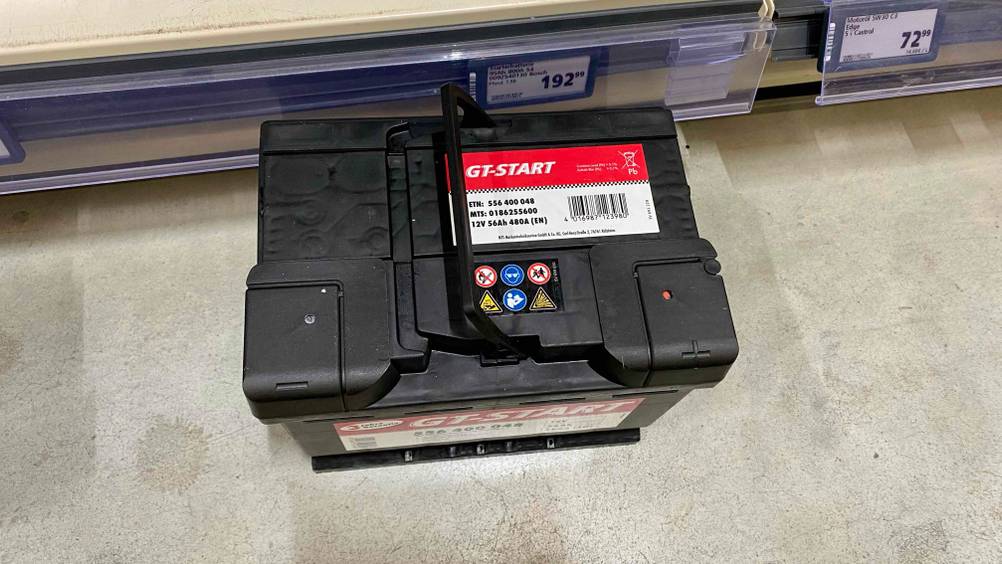 Eine getestete Autobatterie von oben auf einem Betonboden.