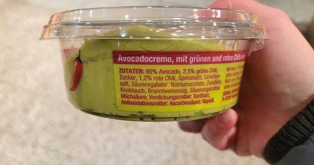 Guacamole getestet: Seitenansicht der Packung von einer Hand gehalten.