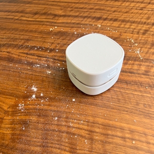 Pulverisierter Zucker auf Tischplatte, zusammen mit dem Gudoqi-Tischstaubsauger CE2382.