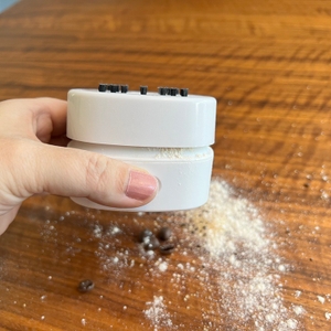 Pulver- und Kaffeebohnen-Reste auf Tischplatte und verschmutzter Gudoqi-Tischstaubsauger CE2382.