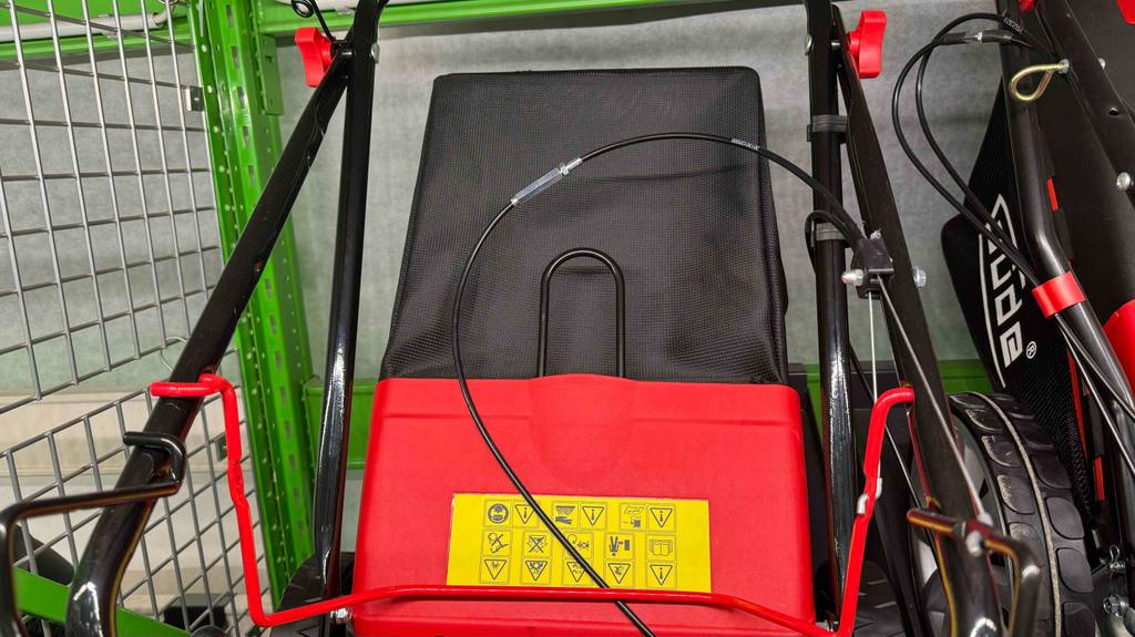 Im Test: ein Benzin-Rasenmäher mit Elektrostarter von Guede, Nahansicht, inklusive Fangkorb.
