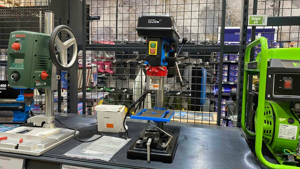 Tischbohrmaschine getestet: Ein Gerät von vorne zwischen anderen Produkten in einem Metallregal.