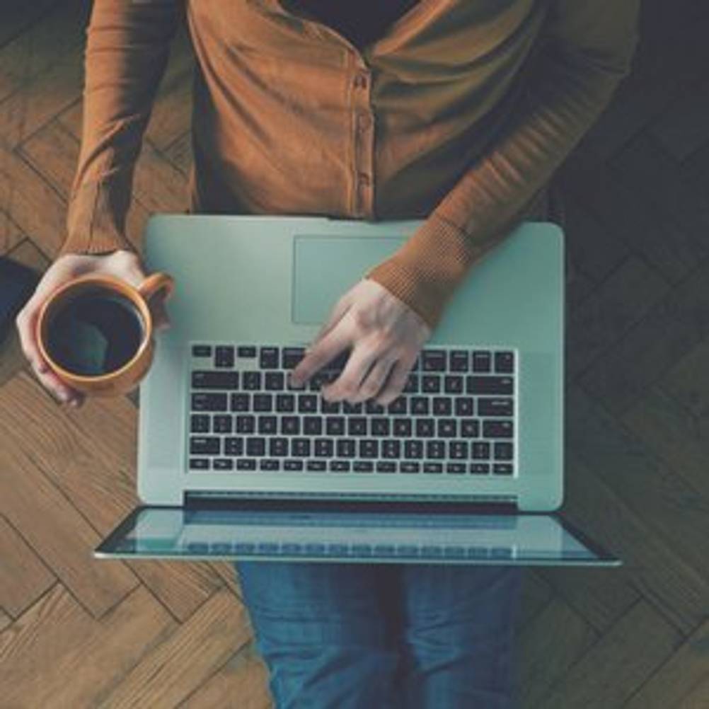 person sitzt gemuetlich am laptop