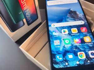 Ein günstiges Smartphone im Test liegt auf einer Holzkiste.