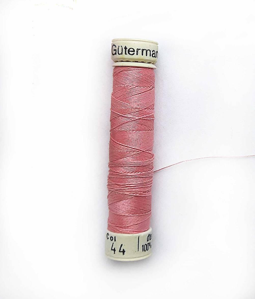 Gütermann-Nähgarn getestet: Ein rosa Garn auf einer hellen Fläche.