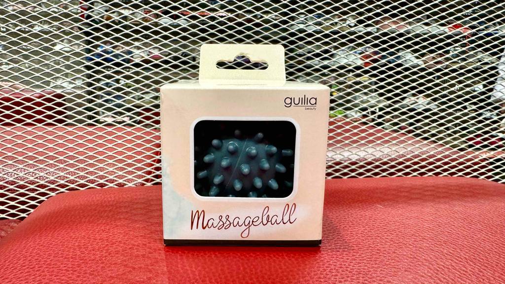 Getestet: Ein Massageball mit Noppen steht in der Verpackung auf einem roten Hocker