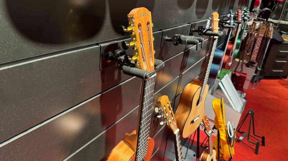 Guitarlele getestet: Nahaufnahme des Kopfes in einem Ständer, im Hintergrund andere Insturmente.