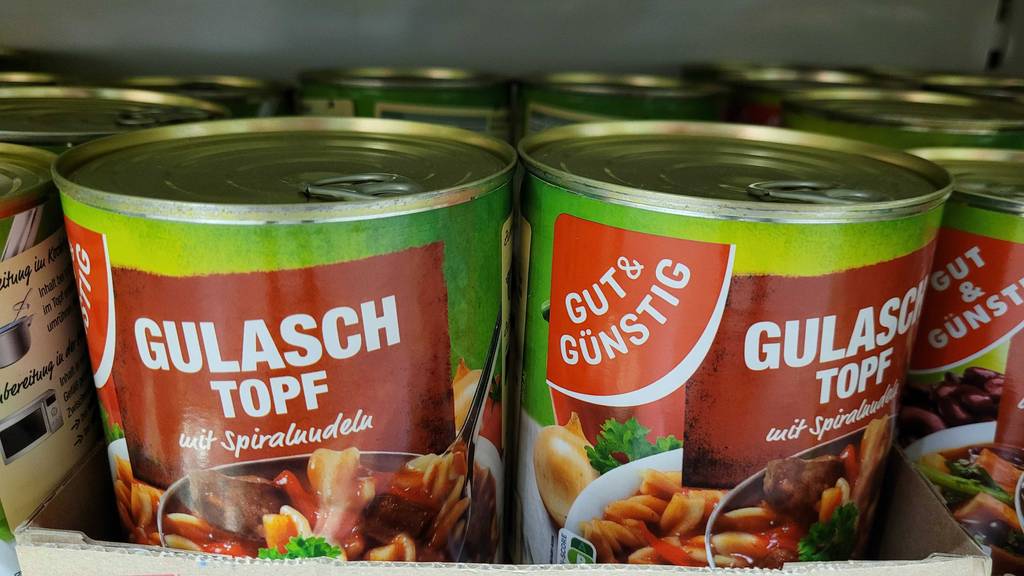 Mehrere Dosen Gulaschtopf von Gut & Günstig stehen im Regal.