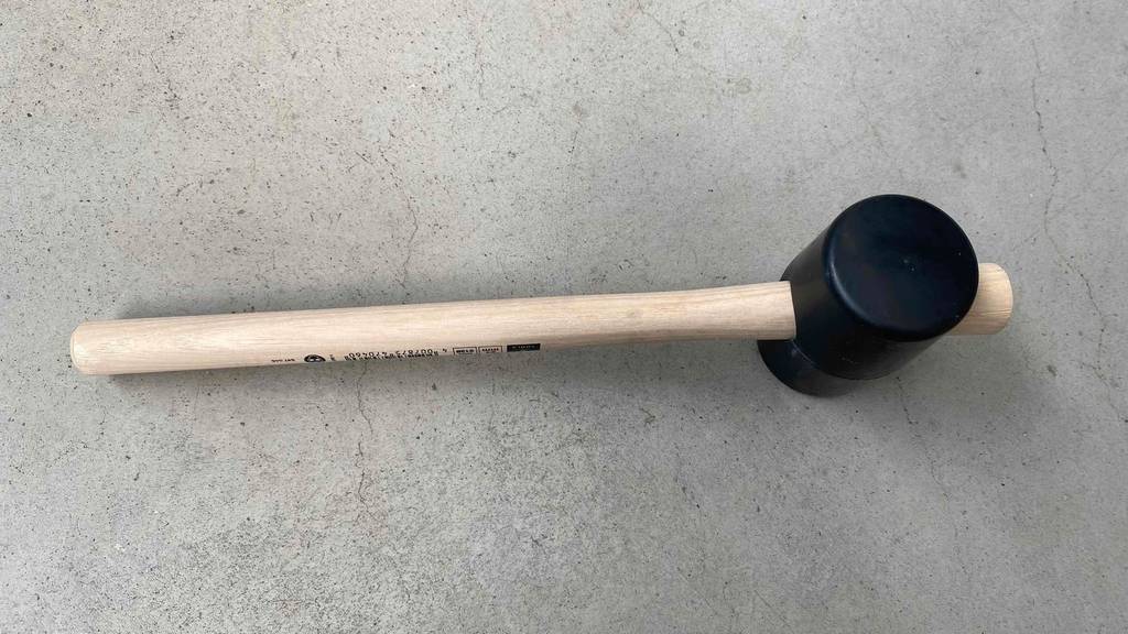 Gummihammer im Test: Hammer steht auf grauem Untergrund.