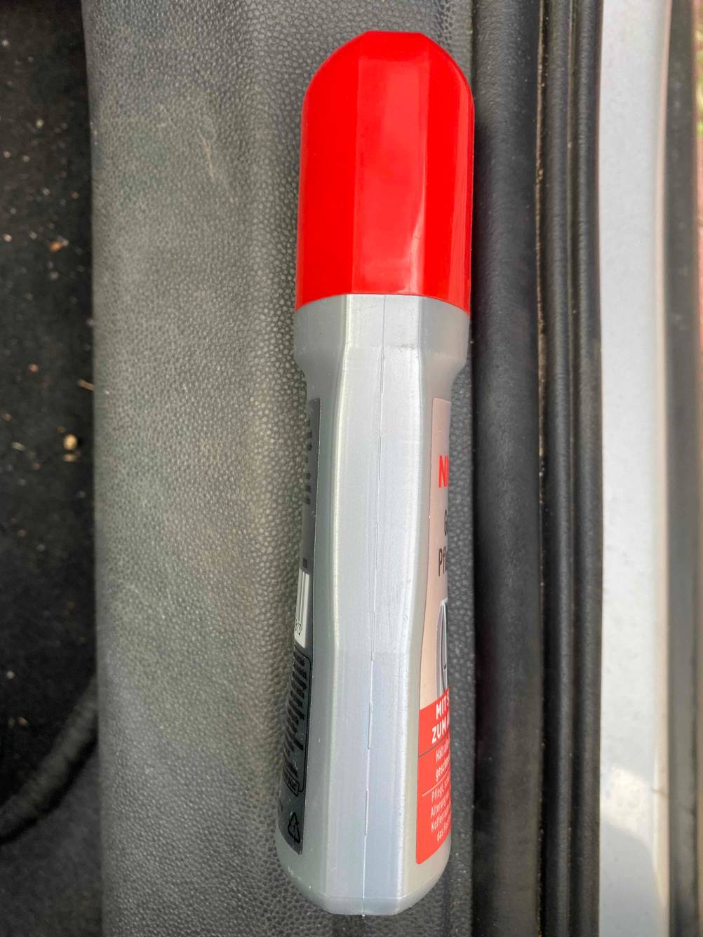 Seitenansicht einer Flasche Gummipflege für das Auto.