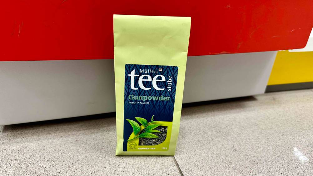Vor einer roten Fläche steht auf dem Boden der getestete Gunpowder-Tee.