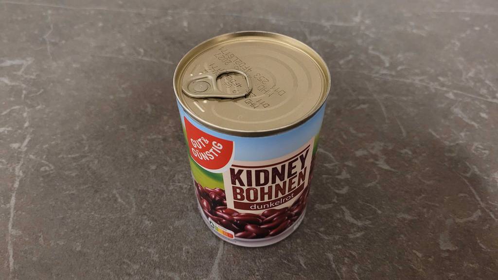 Kidneybohnen im Test: Eine verschlossene Dose mit roten Bohnen steht auf einer dunkelgrauen Küchenarbeitsplatte.